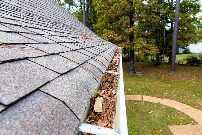 leaves and debris being cleared from a gutter